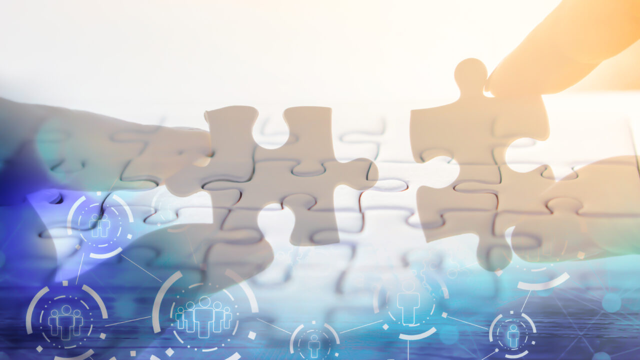 hand holding jigsaw piece with background of teamwork people connection ,business success concept